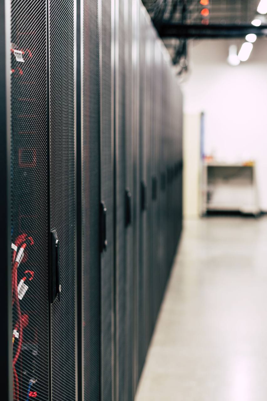 Rows of data-centre racks - local inference trades raw scale for privacy, cost and control.